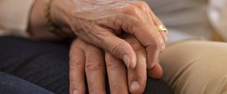 Elderly couple holding hands